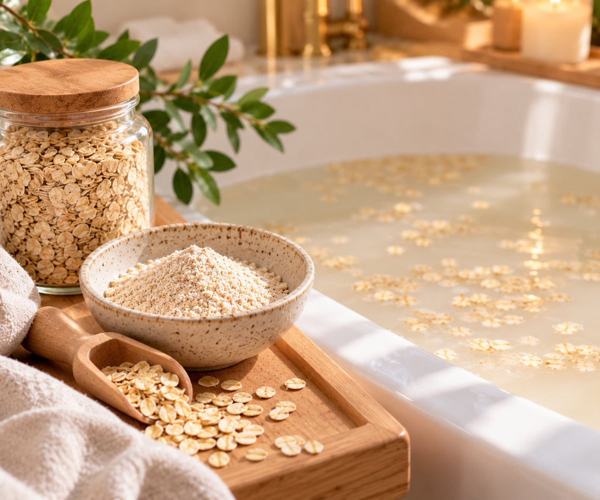 A jar of rolled oats and a bowl of finely ground oatmeal beside a bathtub filled with milky oat water